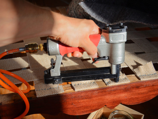 Making new upholstery on old restored furniture. Woman work with